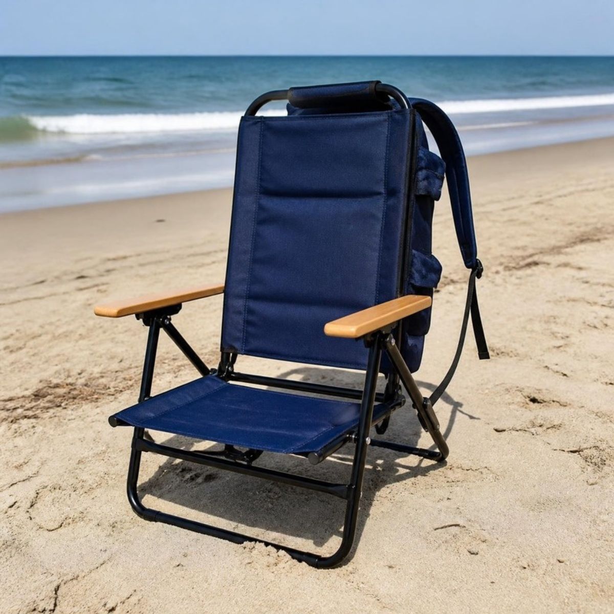 Navy blue folding beach chair with backpack straps and wooden armrests