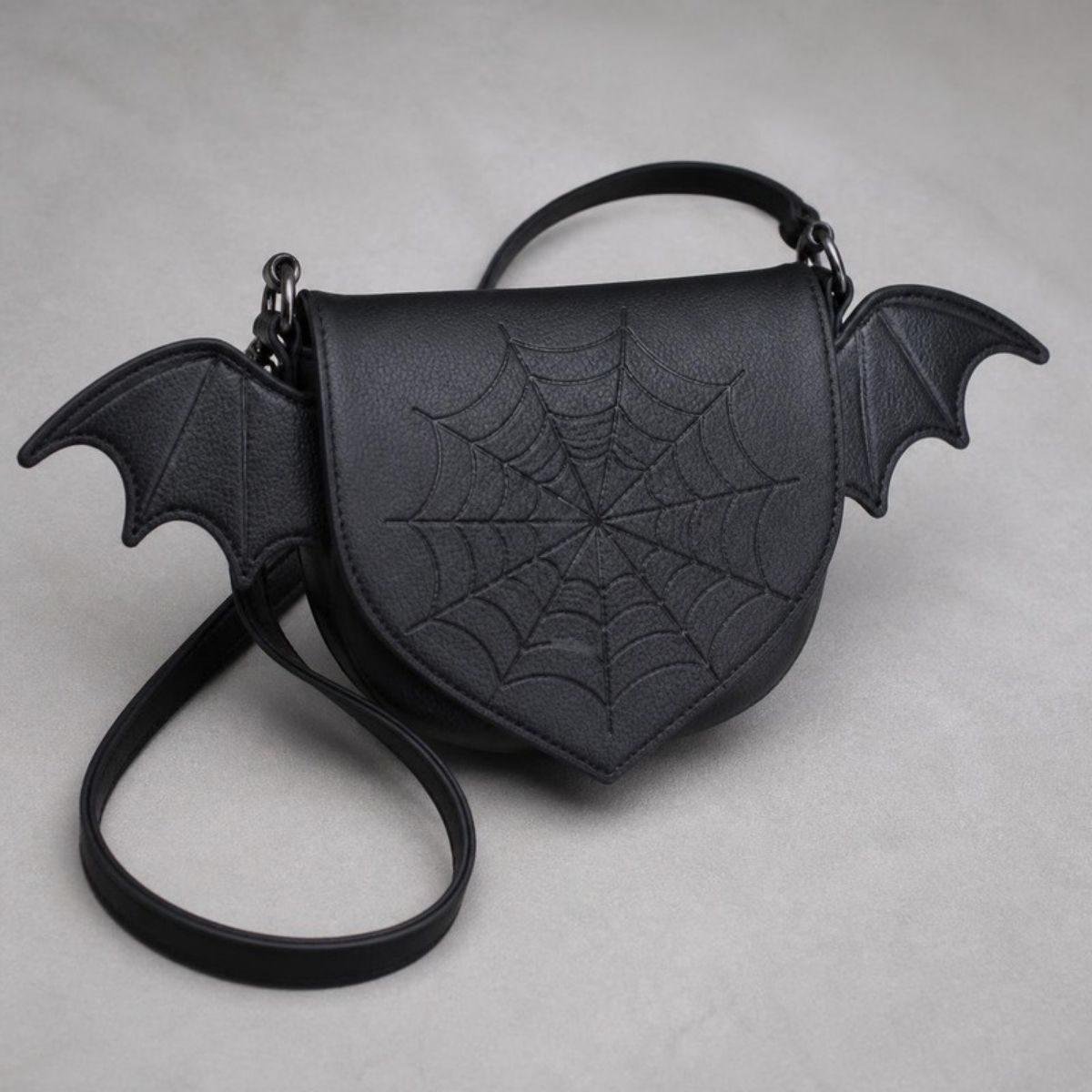 Black crossbody bag with bat wings and a stitched spider web flap