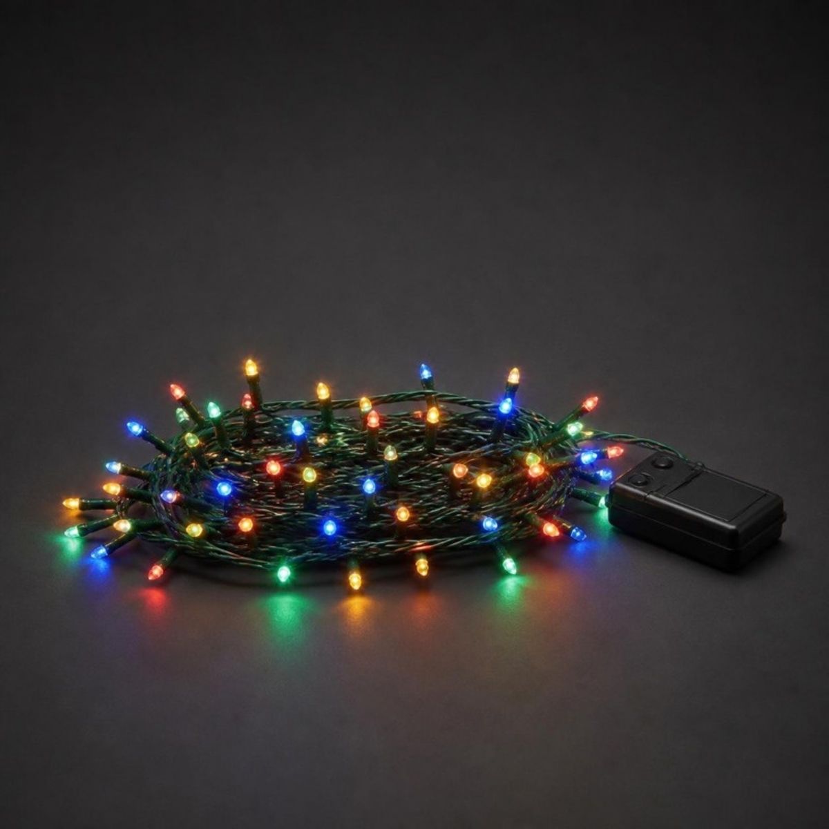 Multicolor LED string lights on green wire with a battery box