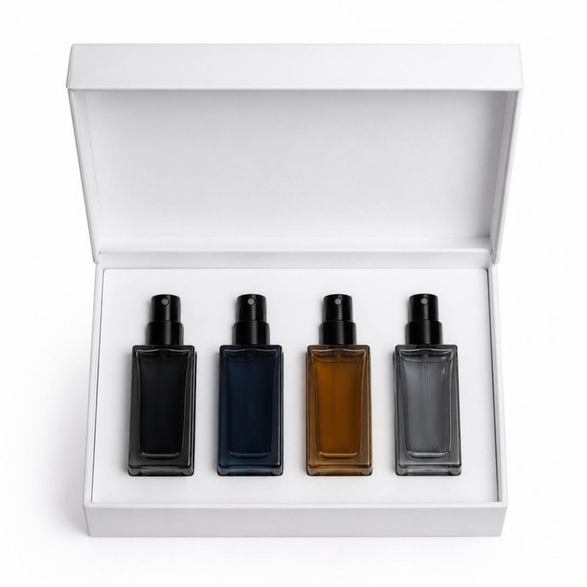 Four small unlabeled perfume bottles in a white gift box