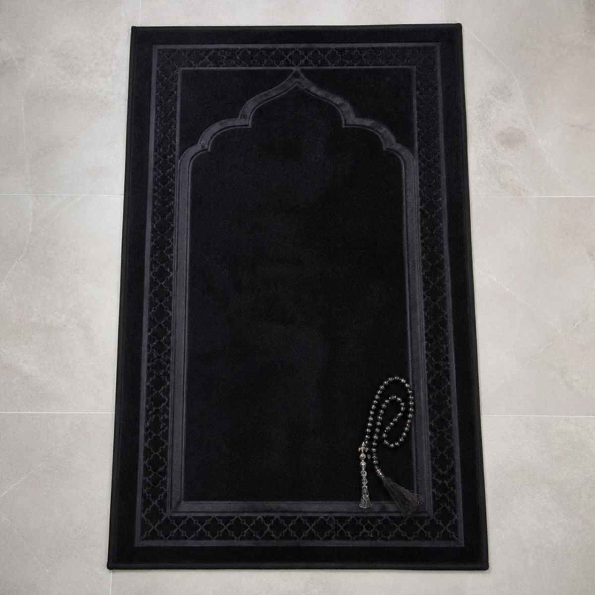 Black padded prayer rug with prayer beads