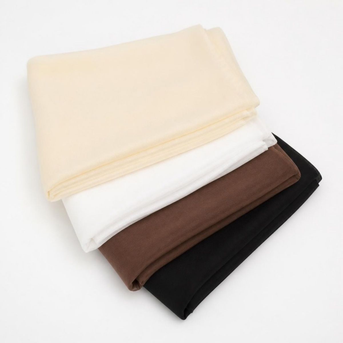 Four folded chiffon scarves in cream, white, brown and black