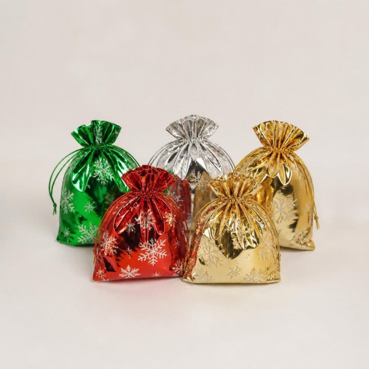 Shiny red, green, silver and gold drawstring gift bags with snowflake prints