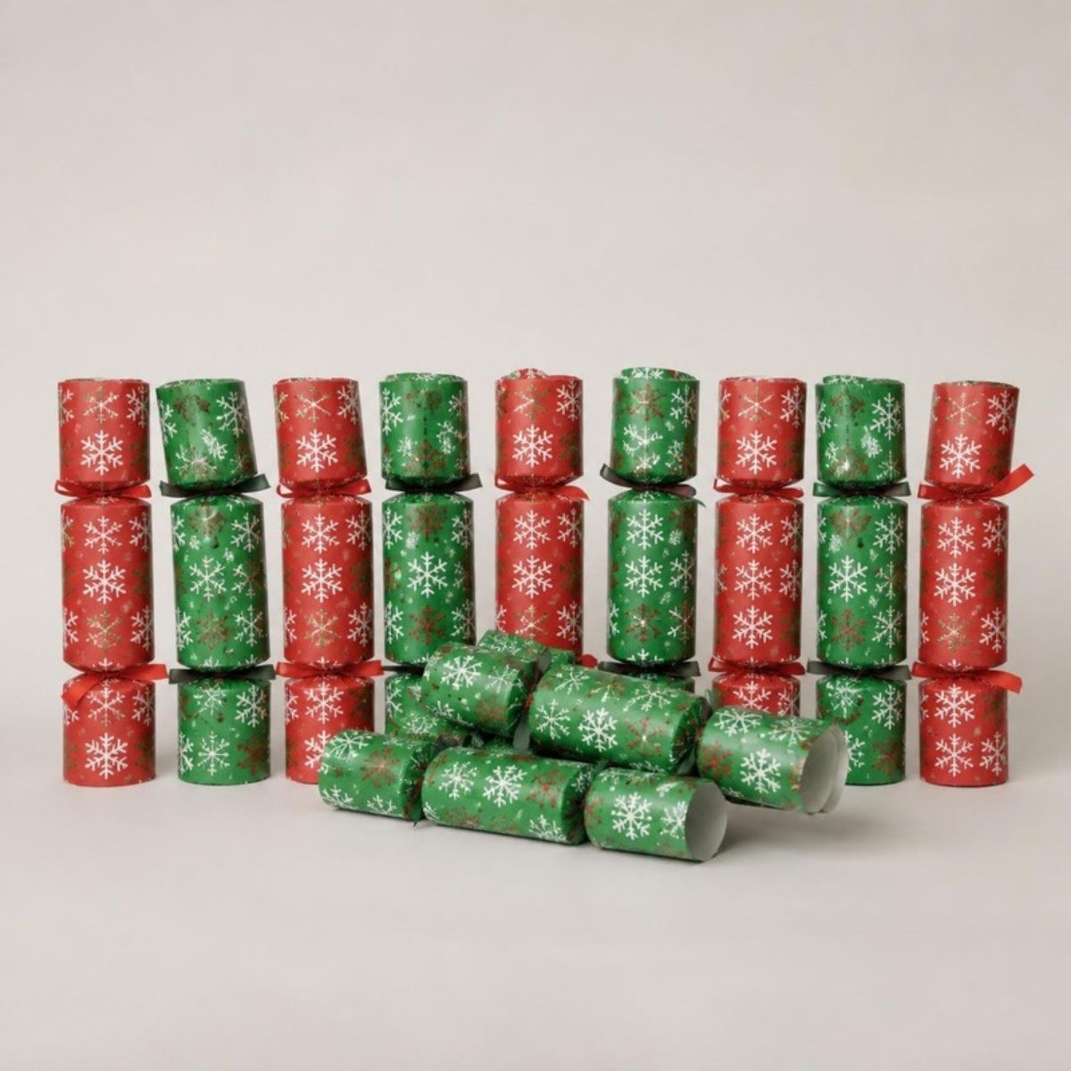 Red and green Christmas party crackers with white snowflakes, tied with ribbons