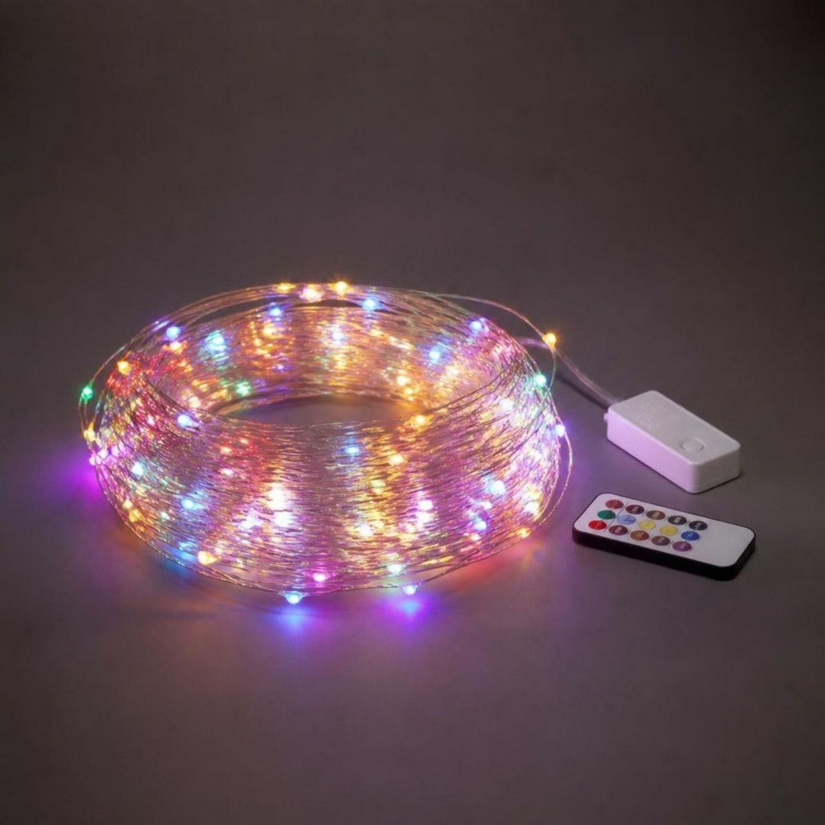 Coil of multicolor fairy lights on silver wire with a control box and remote