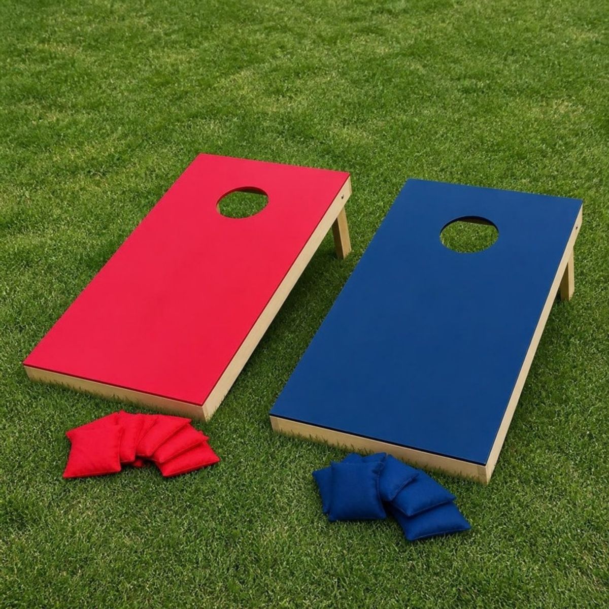 Red and navy cornhole boards on the grass with matching bean bags