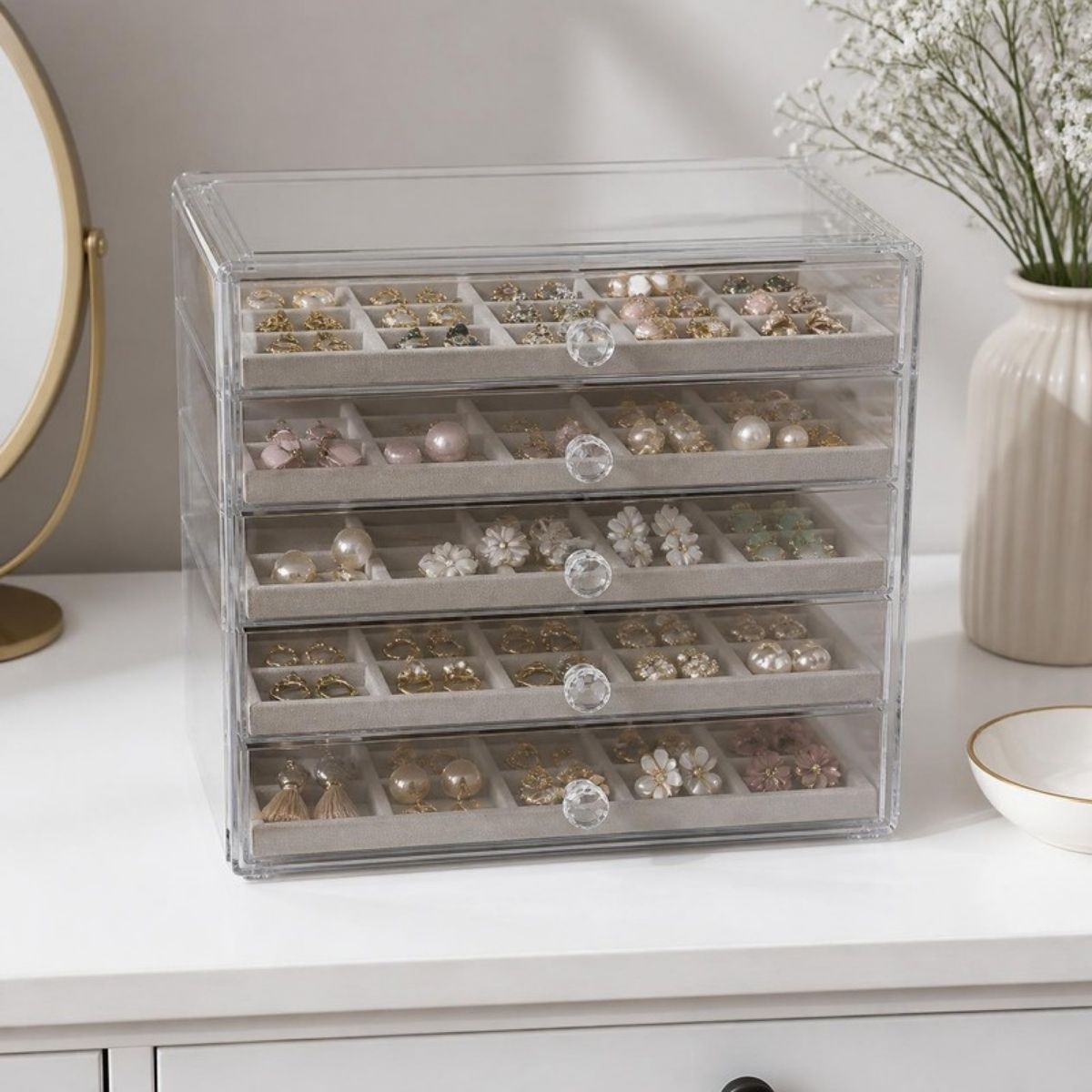 Clear acrylic organizer with five drawers full of earrings