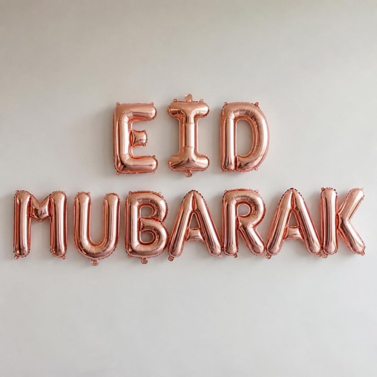 Rose gold foil letter balloons spelling "Eid Mubarak"