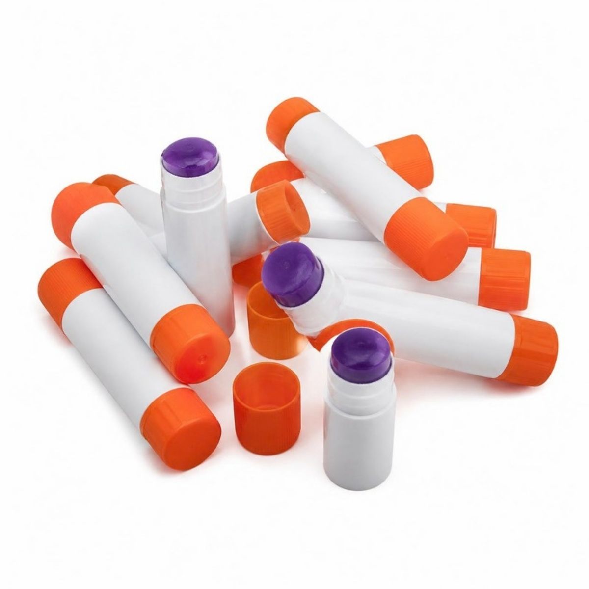 Pile of glue sticks with orange caps and purple glue