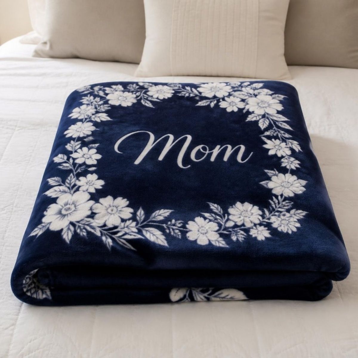 Navy blue throw blanket with white flowers and a "Mom" message