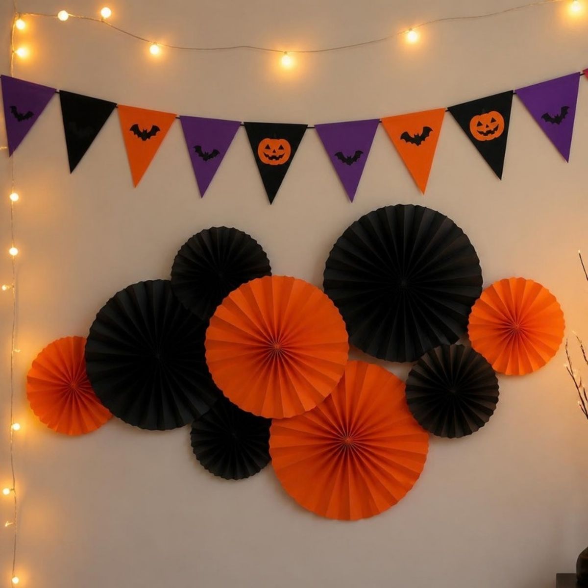 Halloween pennant banner above orange and black paper fans