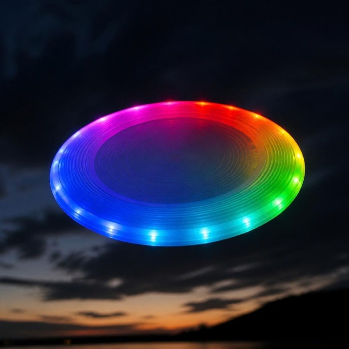 Flying disc glowing in rainbow LED colors against a night sky