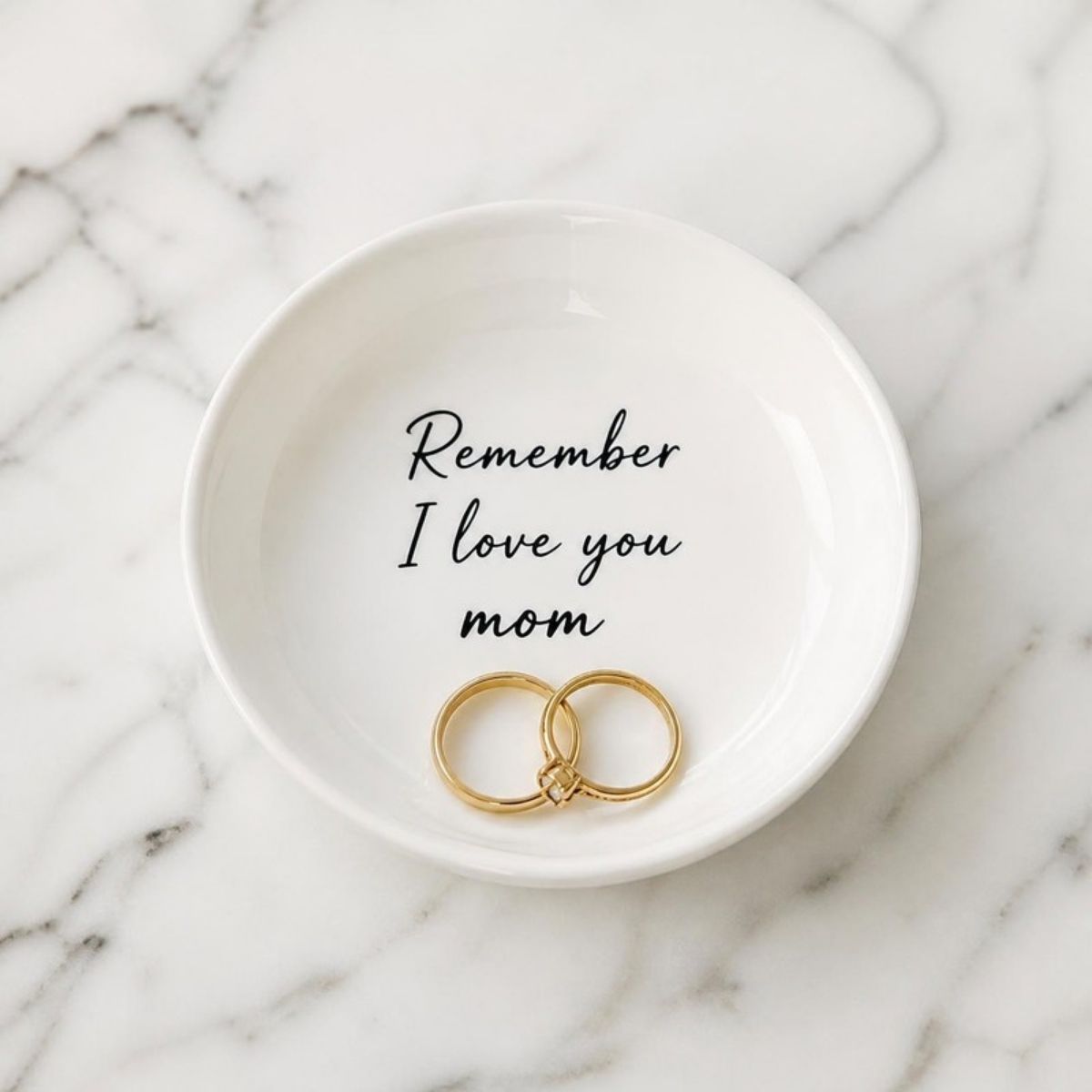 Small white ceramic tray reading "Remember I love you mom" with rings in it