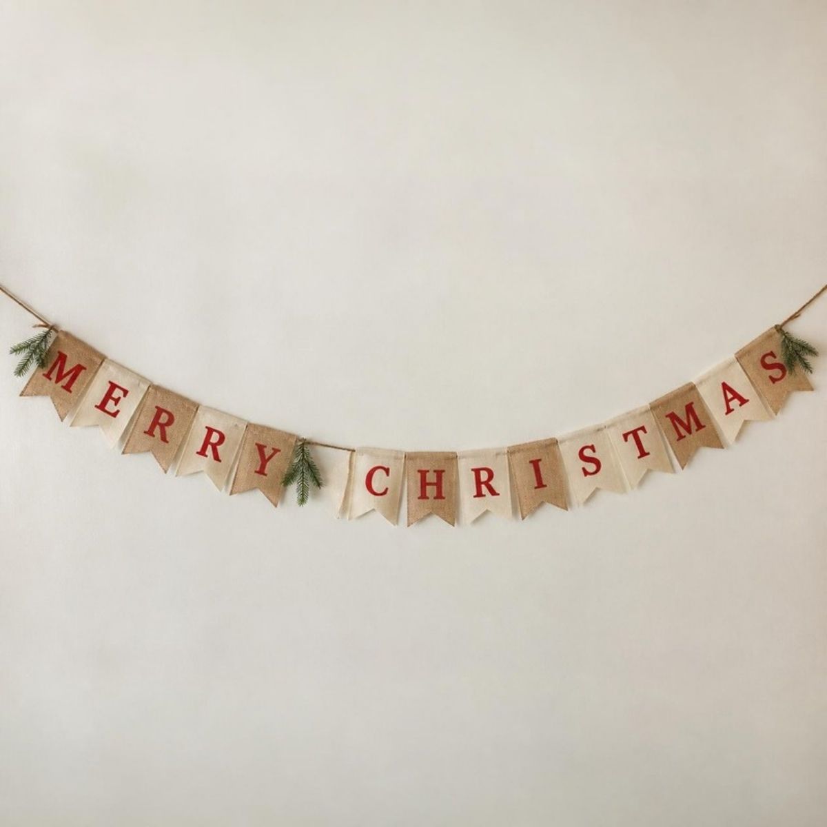Burlap and cream pennant banner spelling "Merry Christmas" in red letters