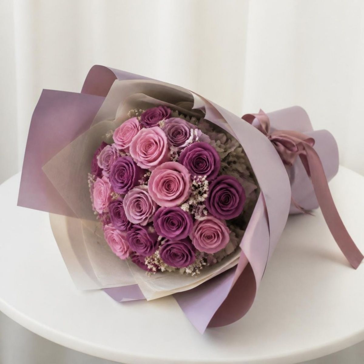 Wrapped bouquet of purple and pink preserved roses