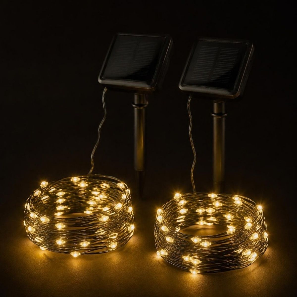 Two coils of warm white fairy lights with solar panel stakes