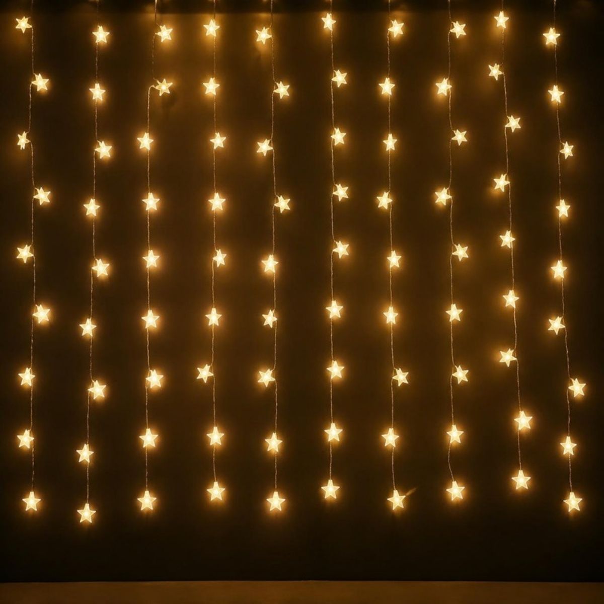 Curtain of warm white star shaped fairy lights