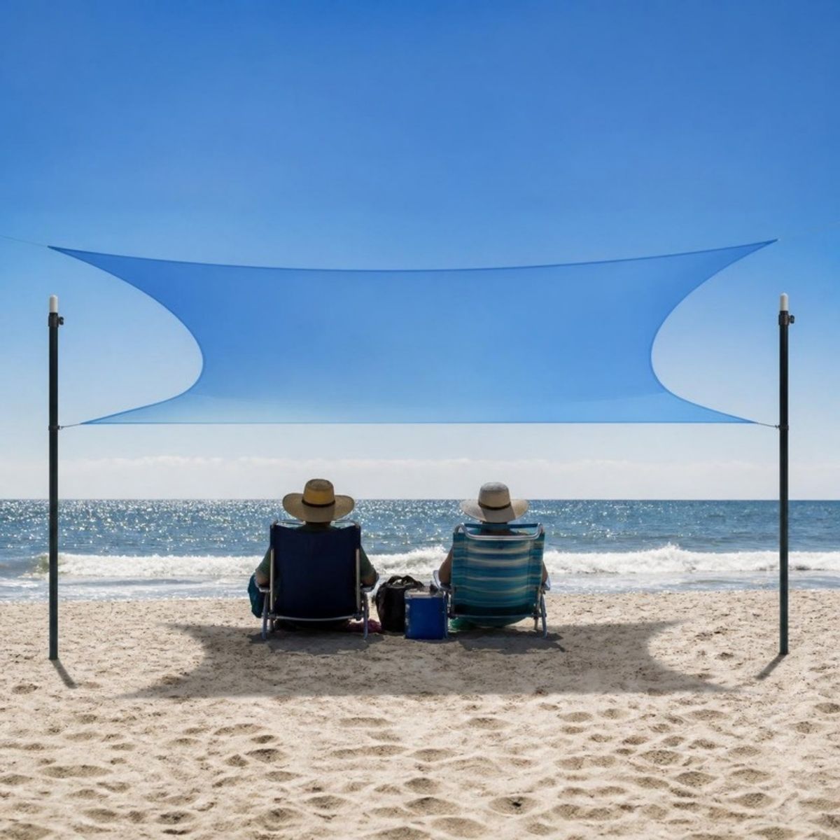 Blue stretch shade canopy on two poles over two people sitting on the beach