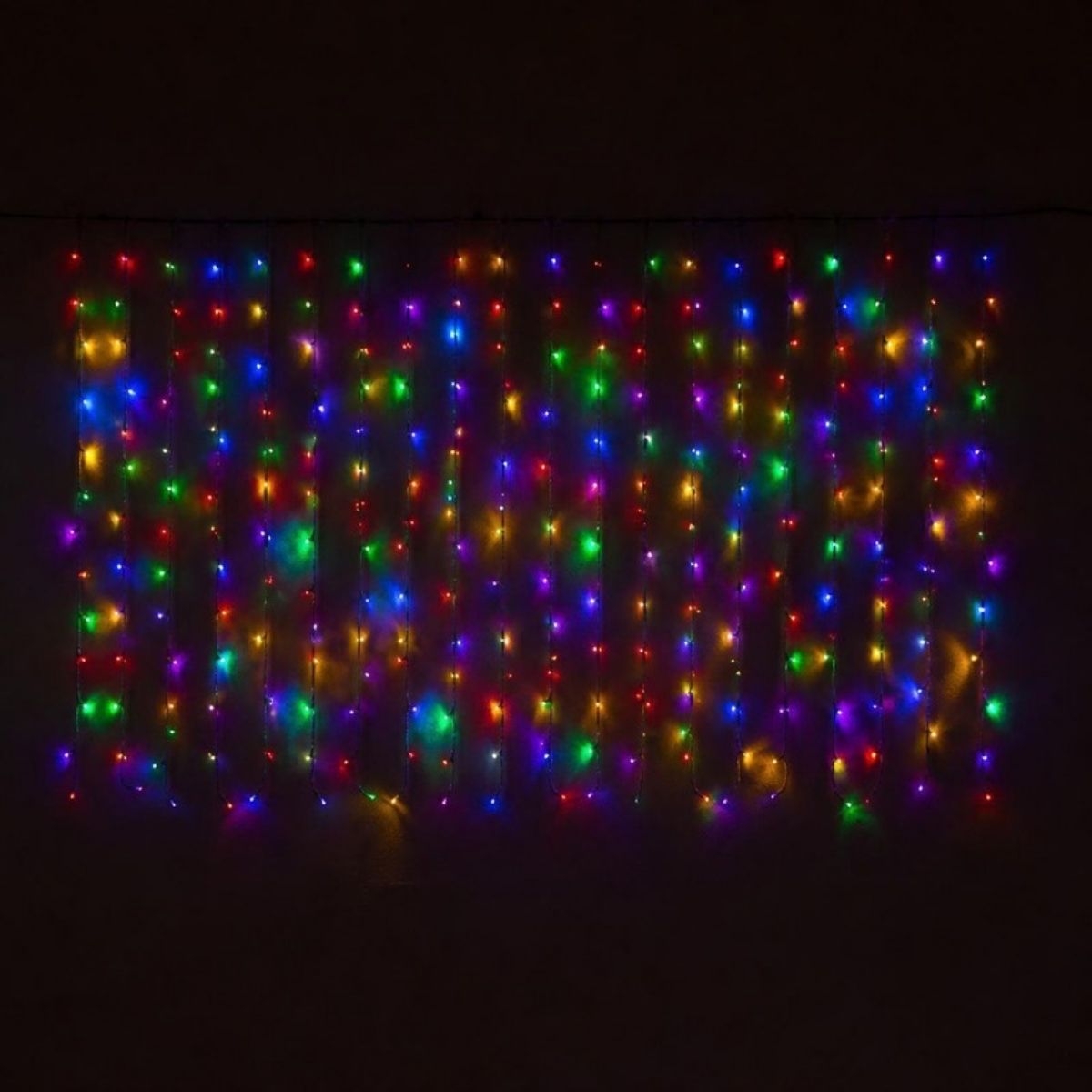 Multicolor curtain of hanging string lights glowing at night