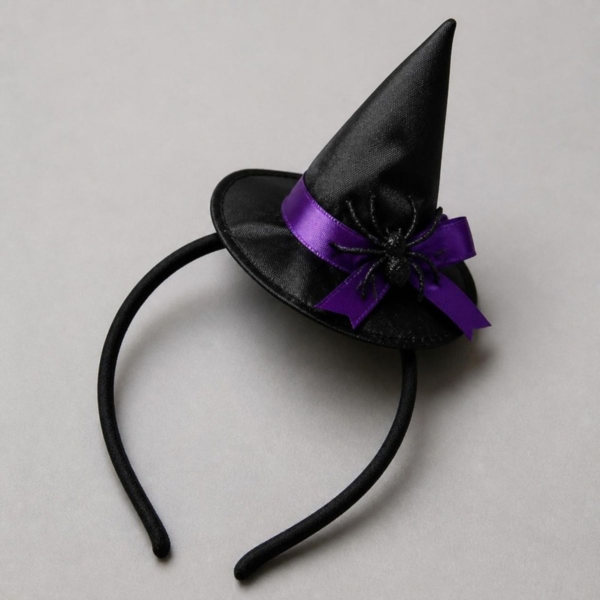 Mini black witch hat headband with a purple bow and spider